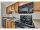 Kitchen features wood cabinets, black appliances including a stove and microwave at 1283 Schaub Dr # B, Raleigh, NC 27606