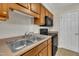 Galley kitchen features black appliances, double basin sink, and wood cabinets at 1283 Schaub Dr # B, Raleigh, NC 27606