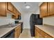 Efficient kitchen with wood cabinets, laminate countertops, and sleek black appliances at 1283 Schaub Dr # B, Raleigh, NC 27606