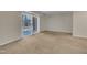 Neutral-toned living room with carpet, sliding glass doors, and bright natural light at 1283 Schaub Dr # B, Raleigh, NC 27606