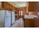 Compact kitchen featuring oak cabinets, neutral tile flooring, and essential appliances at 133 Grassy Rio Ln, Garner, NC 27529