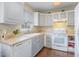 Well-lit kitchen featuring white appliances, light gray cabinets, and a functional layout at 141 Saige Ct, Burlington, NC 27217