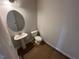 Modern powder room featuring a pedestal sink, oval mirror, and tiled flooring at 144 E Victory View Ter # 66, Smithfield, NC 27577