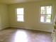 Bright living room with neutral paint, tiled floors, and two large windows at 1505 Harth Dr, Garner, NC 27529