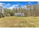 A picturesque one-story home sits on a grassy lot with mature trees in the background under a blue sky at 188 Hunter Ln, Zebulon, NC 27597
