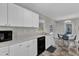 The kitchen area is equipped with white cabinets, black appliances, and offers views to the dining and outdoors at 188 Hunter Ln, Zebulon, NC 27597