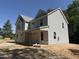 Two-story home features a gray exterior, covered porch, and large windows under a clear blue sky at 1945 Cranes Creek Rd, Cameron, NC 28326