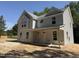 Two-story home with gray siding, a covered porch, and an inviting facade set against a backdrop of mature trees at 1945 Cranes Creek Rd, Cameron, NC 28326