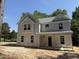 Two-story home featuring a symmetrical facade, gray siding, and architectural shingles under a blue sky at 1945 Cranes Creek Rd, Cameron, NC 28326