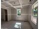 An unfinished living room featuring tray ceilings, multiple windows, and electrical wiring. Ready for customization at 1945 Cranes Creek Rd, Cameron, NC 28326