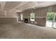 Unfinished living room showing windows for natural light, a fireplace opening, and a sliding glass door to the outside at 1945 Cranes Creek Rd, Cameron, NC 28326