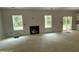 Open-concept living room area with a cozy fireplace, bright windows and sliding doors; awaiting finishing touches at 1945 Cranes Creek Rd, Cameron, NC 28326