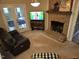 Comfortable living room with a brick fireplace, a dark leather sofa, and access to the back deck at 2000 Mountain Laurel Dr, Clayton, NC 27527