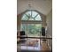Sunlit loft featuring a large arched window showcasing the peaceful scenery, paired with stylish chair and exercise equipment at 2000 Mountain Laurel Dr, Clayton, NC 27527