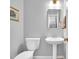 Simple half bathroom with pedestal sink, toilet, mirror, and towel rack at 201 Wortham Dr, Raleigh, NC 27614
