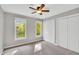 Bright bedroom featuring a ceiling fan, two closets with doors and two windows with a view to the landscape at 201 Wortham Dr, Raleigh, NC 27614