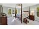 A bedroom with a four-poster bed features neutral walls and plenty of natural light from windows at 201 Wortham Dr, Raleigh, NC 27614