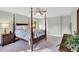 A bedroom with a four-poster bed features neutral walls and plenty of natural light from windows at 201 Wortham Dr, Raleigh, NC 27614
