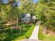 Inviting home surrounded by lush trees and a long driveway, promising privacy and tranquility at 201 Wortham Dr, Raleigh, NC 27614