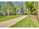 A well-manicured lawn and long driveway lead to a stately home nestled among mature trees at 201 Wortham Dr, Raleigh, NC 27614