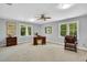 Spacious office features a desk, wooden dresser, a chair, ceiling fan and a lot of natural light from the big windows at 201 Wortham Dr, Raleigh, NC 27614