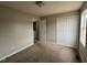 Bedroom with neutral walls, carpeted floor, closet, and adjacent laundry room at 247 Anna St, Lillington, NC 27546