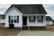 Charming home featuring a cozy front porch, white siding, and black shutters at 247 Anna St, Lillington, NC 27546
