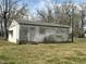 An exterior view of a cinderblock outbuilding and yard with some mature trees at 2904 Jefferson Davis Hwy, Sanford, NC 27332