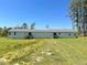 View of the back exterior of the modular home in a yard with green grass and a blue sky at 30 Chaney Ln, Louisburg, NC 27549