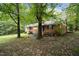 View of home's exterior and lush backyard, surrounded by mature trees offering shade at 313 Main St, Knightdale, NC 27545
