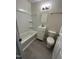 Compact bathroom with a shower-tub combo, white vanity, and updated toilet at 313 Main St, Knightdale, NC 27545