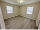 Bright bedroom featuring neutral walls, new flooring and two windows for natural light at 313 Main St, Knightdale, NC 27545