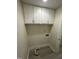 Functional laundry room with overhead white cabinets and new flooring at 313 Main St, Knightdale, NC 27545