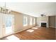 Bright living room featuring hardwood floors, a fireplace, and access to the outdoors through glass doors at 3316 Perkins Ridge Rd, Raleigh, NC 27610