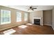 Cozy living room featuring wood floors, a fireplace, and large windows for natural light at 3316 Perkins Ridge Rd, Raleigh, NC 27610