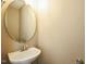 Cozy powder room showcasing a pedestal sink and a round mirror at 3316 Perkins Ridge Rd, Raleigh, NC 27610