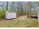 A backyard featuring a shed and a wooden deck, surrounded by trees at 340 Castleberry Rd, Clayton, NC 27527
