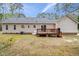 View of the back of the house with a deck, neutral siding, and well-maintained lawn at 340 Castleberry Rd, Clayton, NC 27527