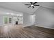 Open concept living area showcasing wood-look floors, leading to a kitchen with white cabinets and stainless appliances at 340 Castleberry Rd, Clayton, NC 27527
