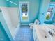 Bright bathroom with blue walls, white fixtures, and a window offering a view of the backyard at 357 Riverwood Dr, Clayton, NC 27527