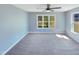 Bright bedroom featuring a ceiling fan, carpet flooring, and ample natural light from the windows at 357 Riverwood Dr, Clayton, NC 27527