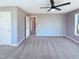 Carpeted bedroom with a ceiling fan, a door leading to a hallway, and natural light from the window at 357 Riverwood Dr, Clayton, NC 27527