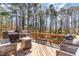 Relaxing back deck featuring wood decking, gas grills, comfortable seating, and a wooded backdrop at 3601 Tartancroft Pl, Fuquay Varina, NC 27526