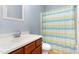 Cozy bathroom with a modern single sink vanity and a blue and green striped shower curtain at 3601 Tartancroft Pl, Fuquay Varina, NC 27526