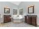 Bright bathroom features dual vanities, soaking tub with corner windows and ceramic tile flooring at 3601 Tartancroft Pl, Fuquay Varina, NC 27526