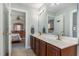 Bright bathroom featuring double sinks, white countertops, and light blue walls leading to the main bedroom at 3601 Tartancroft Pl, Fuquay Varina, NC 27526