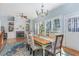 Bright dining room with fireplace, built-ins, and a long wooden table illuminated by natural light from the windows at 3601 Tartancroft Pl, Fuquay Varina, NC 27526