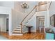 Grand foyer featuring a staircase, chandelier, wood floors, and an open view to the front entrance at 3601 Tartancroft Pl, Fuquay Varina, NC 27526