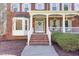 Inviting front porch with brick steps, white columns, and blue door creating a warm entry at 3601 Tartancroft Pl, Fuquay Varina, NC 27526