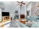 Bright living room with a fireplace, light blue walls, ceiling fan, and views to the second floor at 3601 Tartancroft Pl, Fuquay Varina, NC 27526
